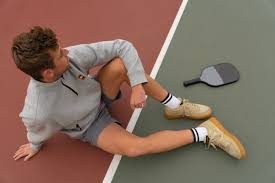 Player in orange shirt demonstrating ready position at the net
